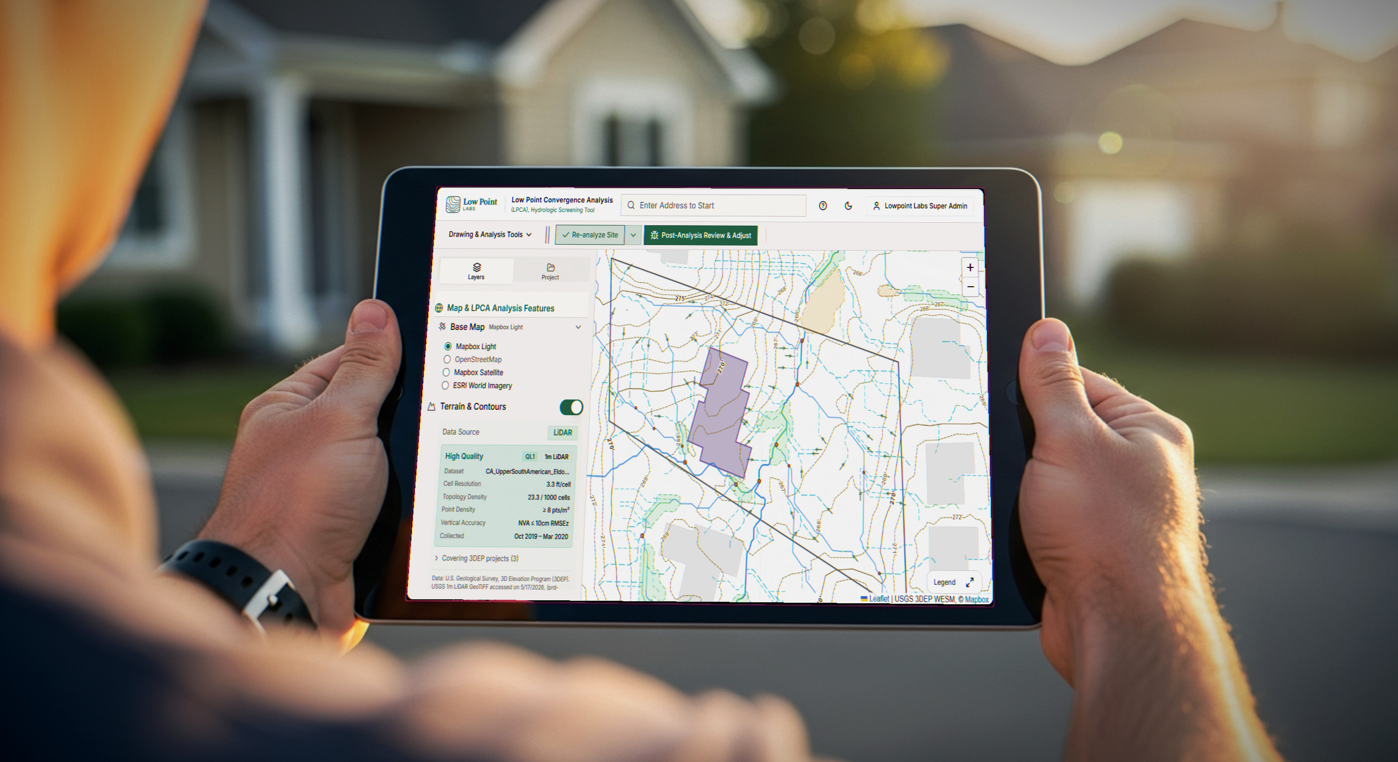 Professional reviewing a Drainage Intelligence Report on a tablet in the field